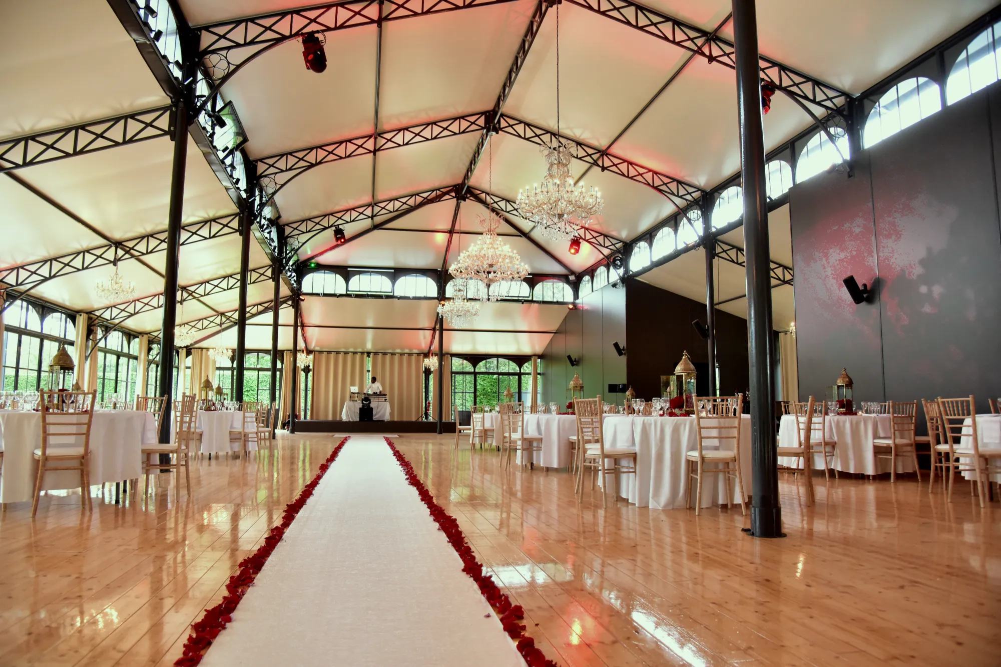 L'Orangerie dressée pour un dîner, allée rouge et tables rondes