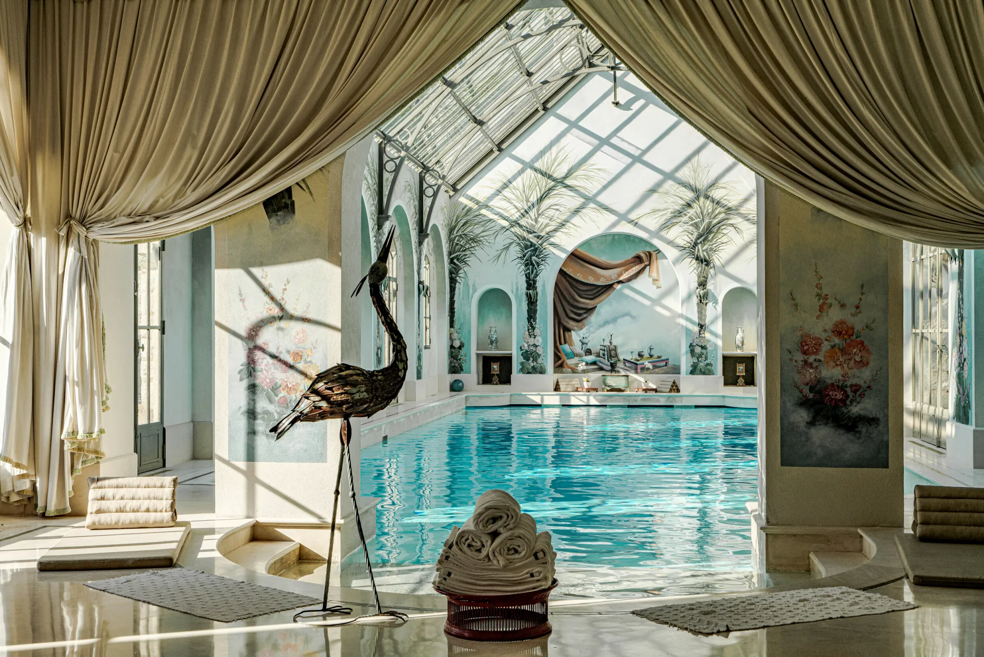 La piscine sous sa verrière, fresques de palmiers