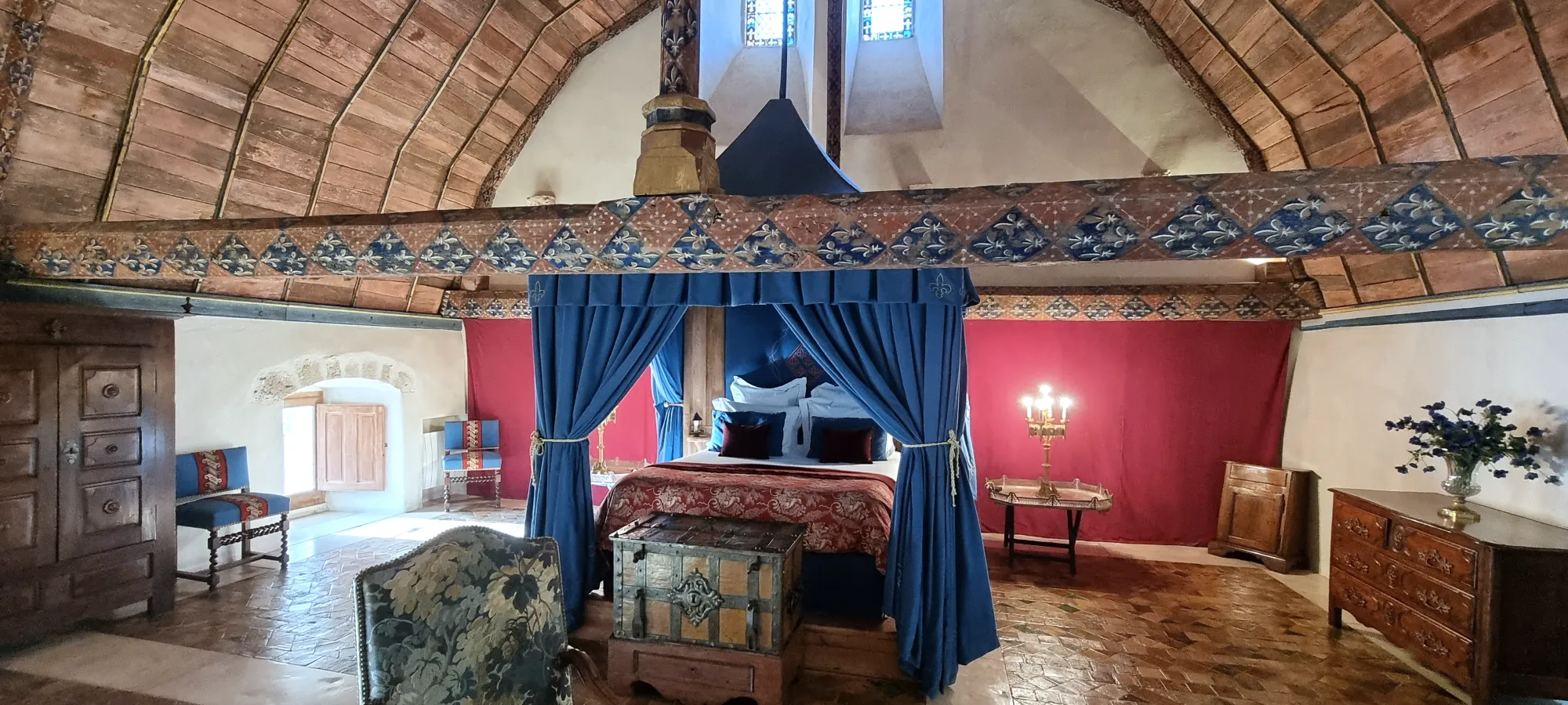 Une chambre bleue du château, lit et fauteuils sous les boiseries